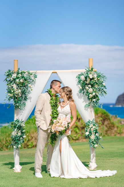 Wedding couple in front of an arch in Hawaii