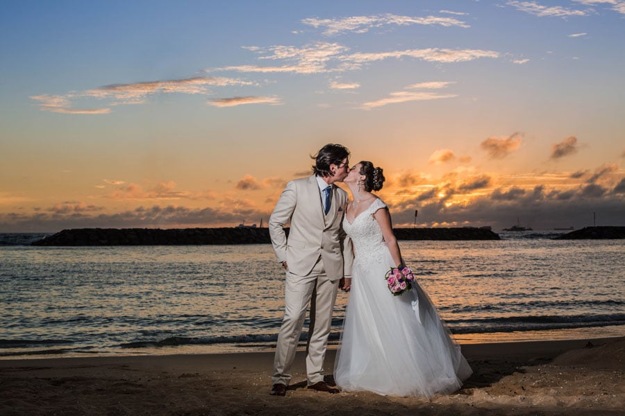 Newlyweds kissing on a beach in Hawaii