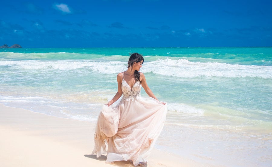 A bride spinning her wedding dress on the beach