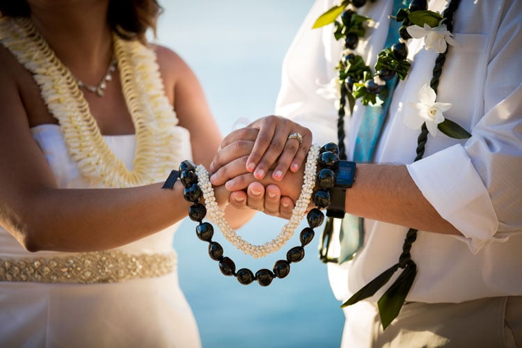 A wedding couple holding leis in Hawaii