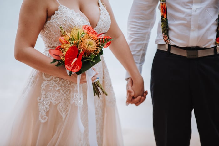 Bride holds a tropical bridal bouquet at a beach wedding at Kawela Bay