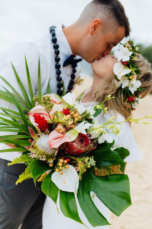 Custom tropical bouquet with matching haku lei on a beach in Hawaii