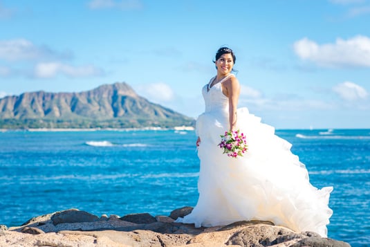 A bride posing with Diamond Head in the background on Oahu.