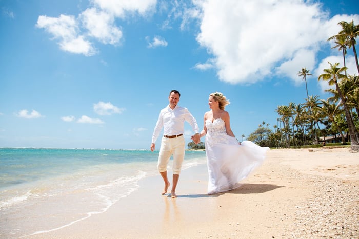 Eloping couple walking on a beach in Hawaii